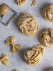 Homemade strips of pasta wrapped into nests and sprinkled with semolina flour.