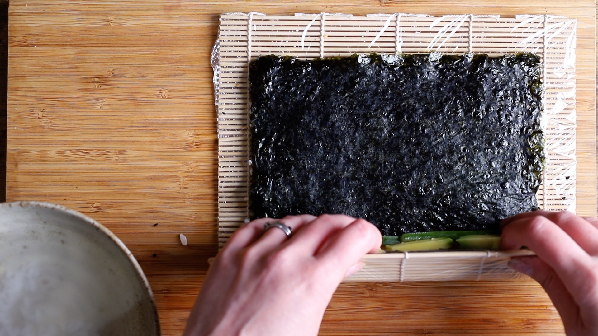 use the mat to start rolling the sushi roll