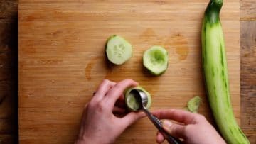 use a melon baller and knife to hollow out the cucumber