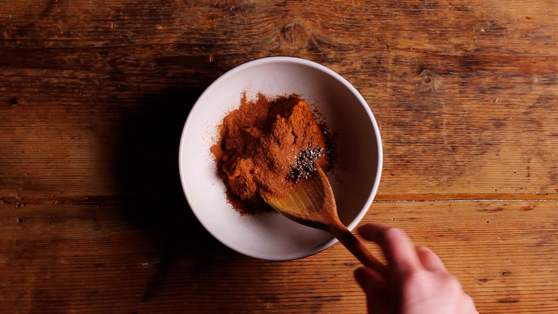 adding spices to a bowl