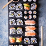 platter of sushi with pickled ginger, soy sauce and chopsticks