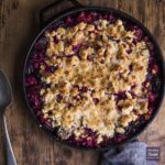 Rhubarb crumble recipe in a round cast iron pan with spoon
