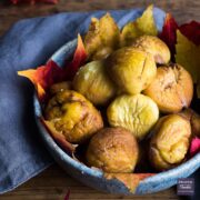 Bowl of roasted and peeled chestnuts with autumnal leaves lining the bowl.